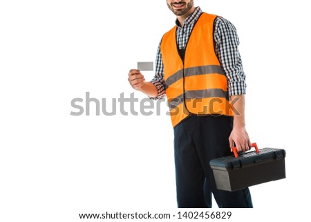 cropped view of construction man in safety vest holding blank business card isolated on white