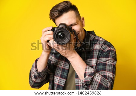 Young male photographer on color background Royalty-Free Stock Photo #1402459826