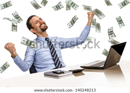 young modern businessman excited with his success while working with his laptop computer with money rain  