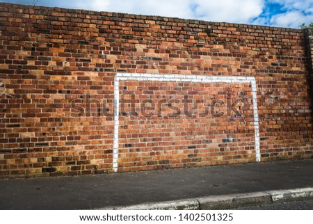 Painted footbal goalpost on a wall in a street. Royalty-Free Stock Photo #1402501325