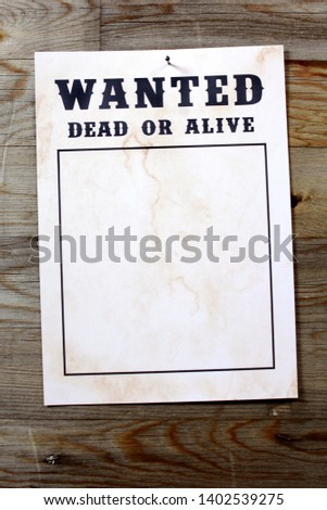 Wanted poster in front of wooden wall with copy space for own picture as a wanted photo
