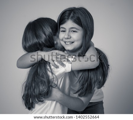 Portrait of two pretty loving sisters hugging each other in happy moments together and older and younger sister relationship. Children friendship and family concept.