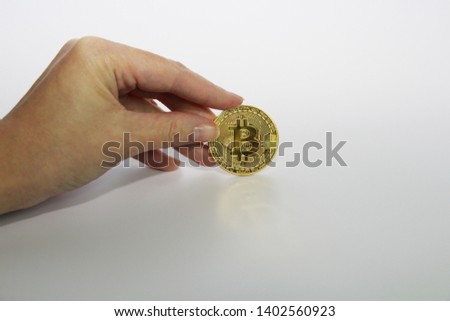 Cryptocurrency concept golden bitcoin. A woman holds a gold coin - bitcoin. White background.