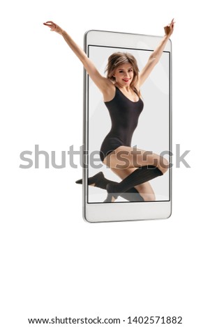 Photo of young beautiful modern female dancer jumping, concept virtual reality of the smartphone. going out of the device