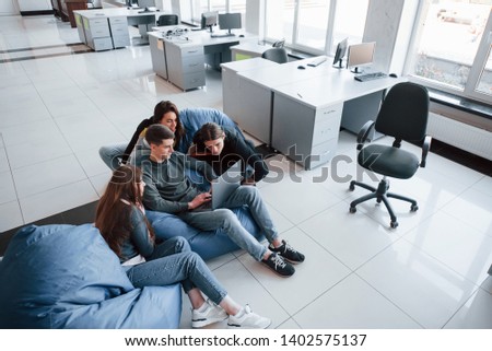 Need to look closer. Group of young people in casual clothes working in the modern office.