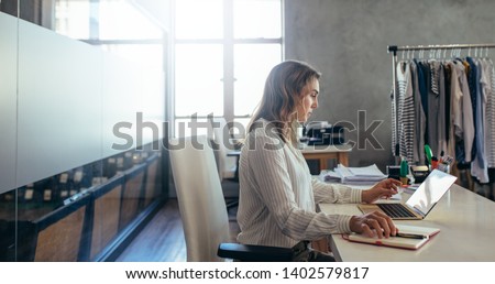 Woman online entrepreneur working on laptop at office. ecommerce business owner working at her desk. Royalty-Free Stock Photo #1402579817
