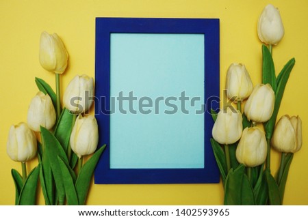 empty of photo frame and tulip flowers bouquet on yellow background