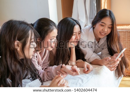 Women friend group use smartphone lying on bed meeting friendship