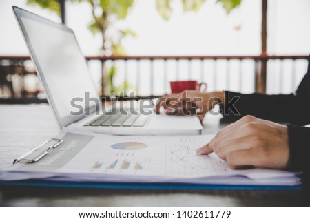 Business analysis concept. Businesswoman analyzing business documents, finacial report, working on laptop computer, mobile smart phone on office desk, close up. Royalty-Free Stock Photo #1402611779