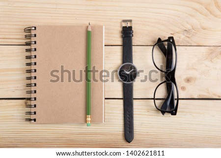 Blank notepad with pen and pencil on office wooden table