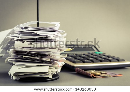Bills in paper nail with calculator and money Royalty-Free Stock Photo #140263030