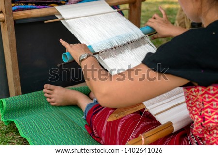 the hill tribe people of thailand weaving in chiang rai with soft-focus and over light in the background. closeup image