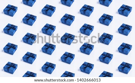 A pattern of blue colored gift boxes with a bow made with ribbon isolated on a white uniform background