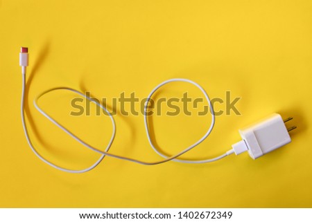 Smartphone USB charger Adapter on a yellow background - images
