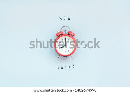 Creative top view flat lay of alarm clock with messages about delay or starting doing task copy space blue background minimal style. Concept of procrastination, time management in business and life Royalty-Free Stock Photo #1402674998