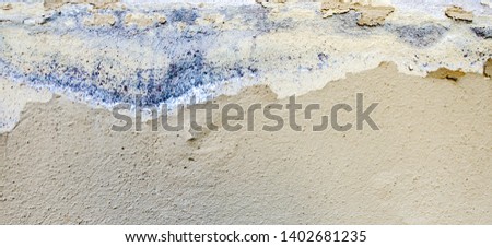 Old weathered painted wall background texture. White dirty peeled plaster wall with falling off flakes of paint.