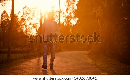 Young man walking around a curvy urban street in the afternoon