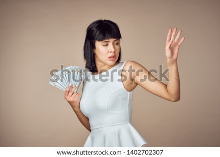 rich woman with money on beige background                              