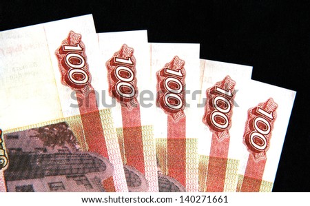 five banknotes in denominations of one hundred units on a dark blue background.