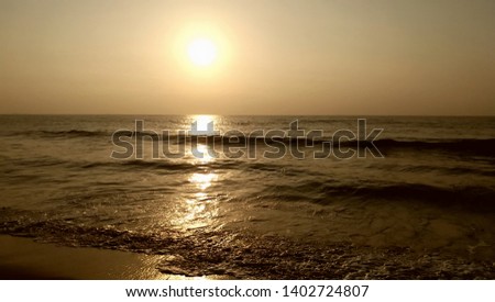 Perfect and beautiful barrel giant wave on beautiful golden color ocean. Waves and sun shine in the morning.  Golden sun rise in landscape, sand and sea waves in detailed view.
