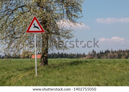 Traffic sign for game trail where wild animals cross the road Royalty-Free Stock Photo #1402755050
