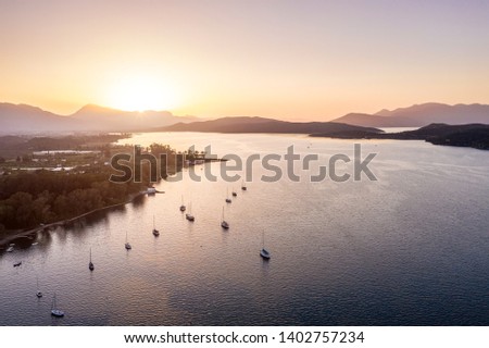 yachts are on the water near the island. Golden sunset sun. Aerial photo
