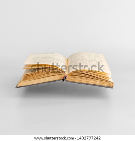 Levitating open old book on white background.  Minimal concept. Copy space Royalty-Free Stock Photo #1402797242