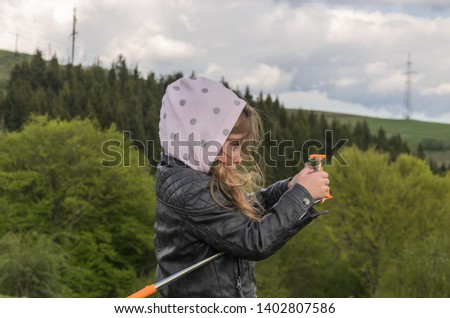 Little girl child takes pictures on the phone of the mountain while traveling
