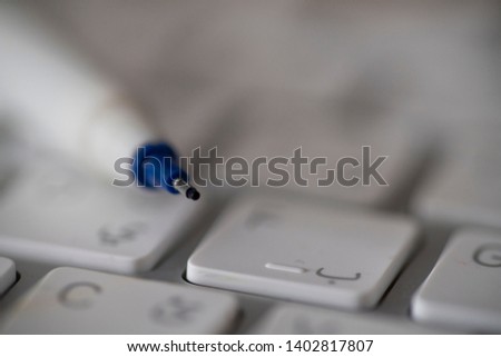Close up shot of a pen tip with keyboard