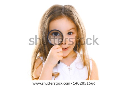 Portrait close-up little girl child looking through magnifying glass isolated on white background