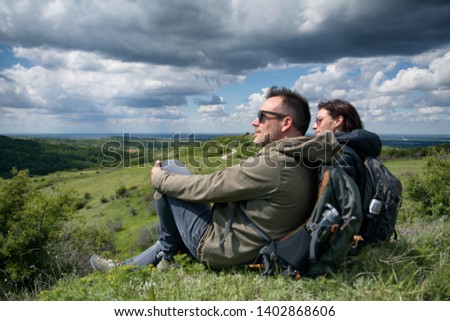 Couple of hikers sitting on the mountain top