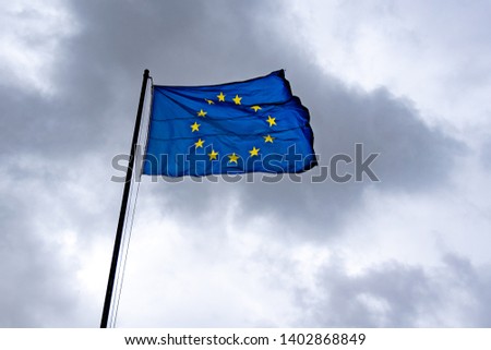 Flag of European Union, EU, on dramatic cloudy sky on background.