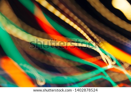 Colorful pattern of golden, green and red dynamic lines of light. Modern blurred background. Art concept of lighting effects.