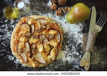 Homemade pizza with pear, cheeses and walnuts.