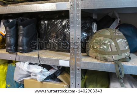 an army camouflage helmet lying on the racks in an army warehouse