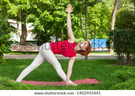 Young woman doing yoga in morning park Portrait