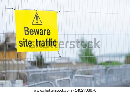 Beware construction site traffic sign on fence
