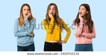 group of people with colorful clothes surprised and shocked while looking right on colorful background