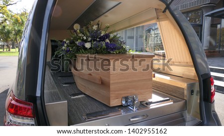 closeup shot of a funeral casket in a hearse or chapel or burial at cemetery

