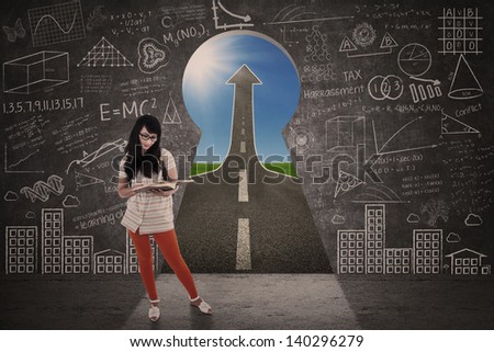 Asian girl is studying in front of keyhole success road landscape