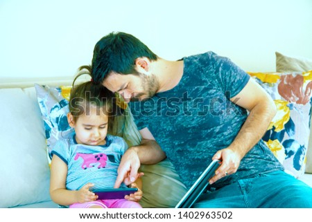 Father and his daughter playing game in notebook