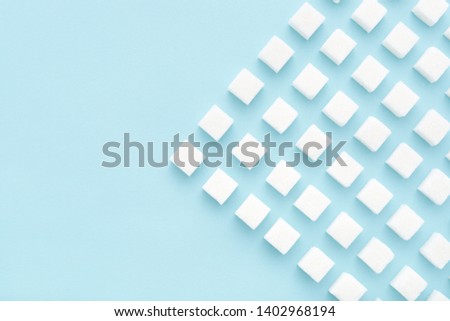 Sugar cubes geometry pattern on light blue background. Copy space, top view, minimal. Royalty-Free Stock Photo #1402968194