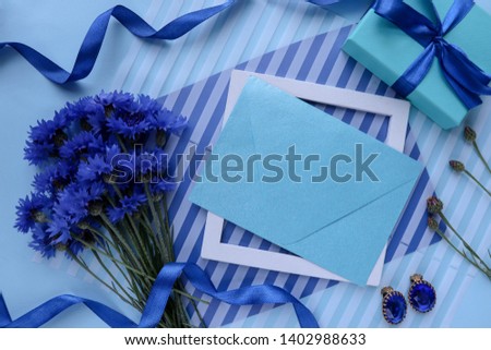 bouquet of cornflowers and an envelope on a white background