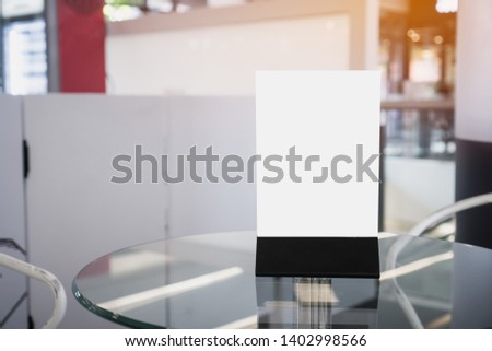 Mock up white Label for blank menu frame in restaurant cafe. Stand booklet sheets paper tent card on table cafeteria display your product blurred background insert  text of customer. Space for texting