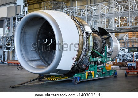 Jet engine remove from aircraft for maintenance at aircraft hangar.Turbine engine maintenance and change part by aircraft technician . Royalty-Free Stock Photo #1403003111