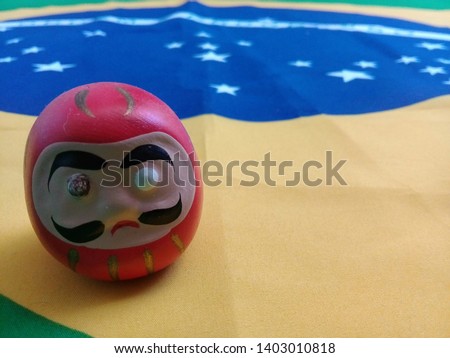 Daruma doll on a Brazilian flag
