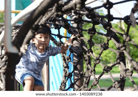 Boys climb the rope in the playground.