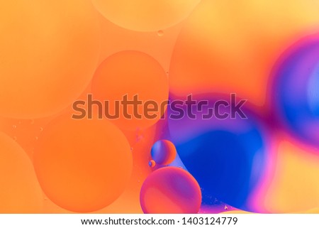 oily drops in water with colorful background, close-up 