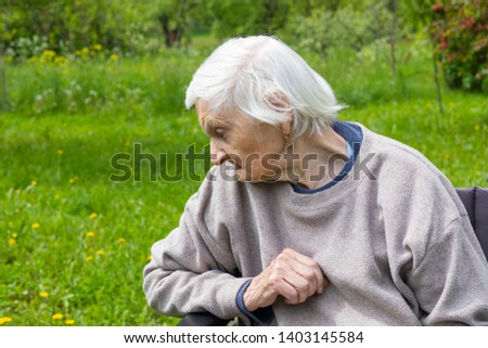 Picture of an old lady sitting in a wheelchair spending time outdoor in the park