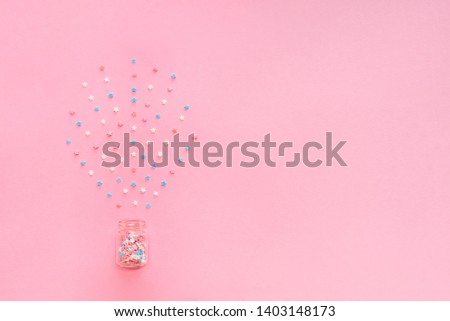 Little stars confetti on pink background. Holiday concept. Copy space for your text.